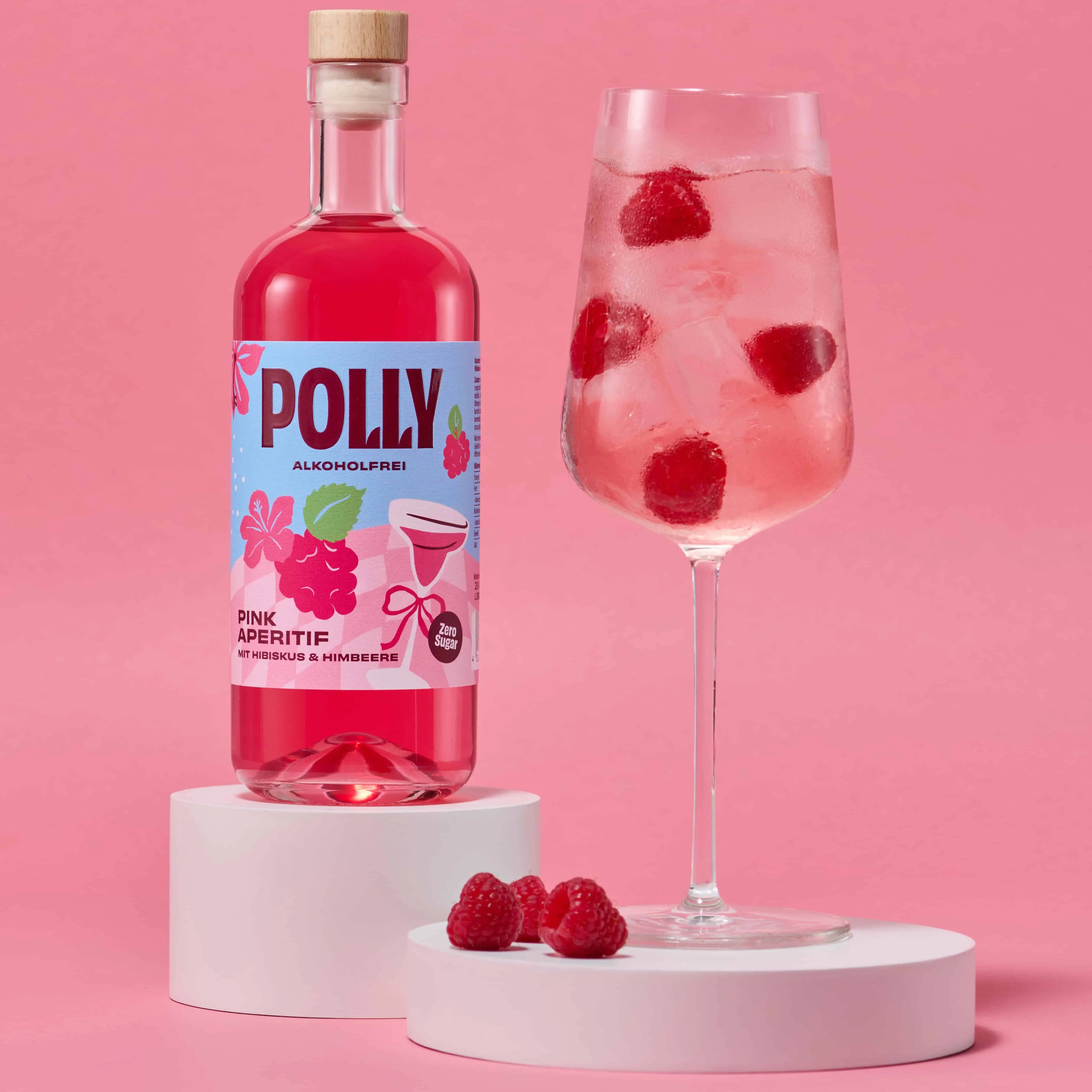 Spritziger pinker Drink mit POLLY Pink Aperitif, Sprite Zero, Eis, Himbeeren und Blaubeeren in einem Glas.