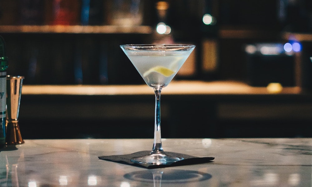 Martini Glas mit Zitronenzeste auf einem Tresen in einer Bar