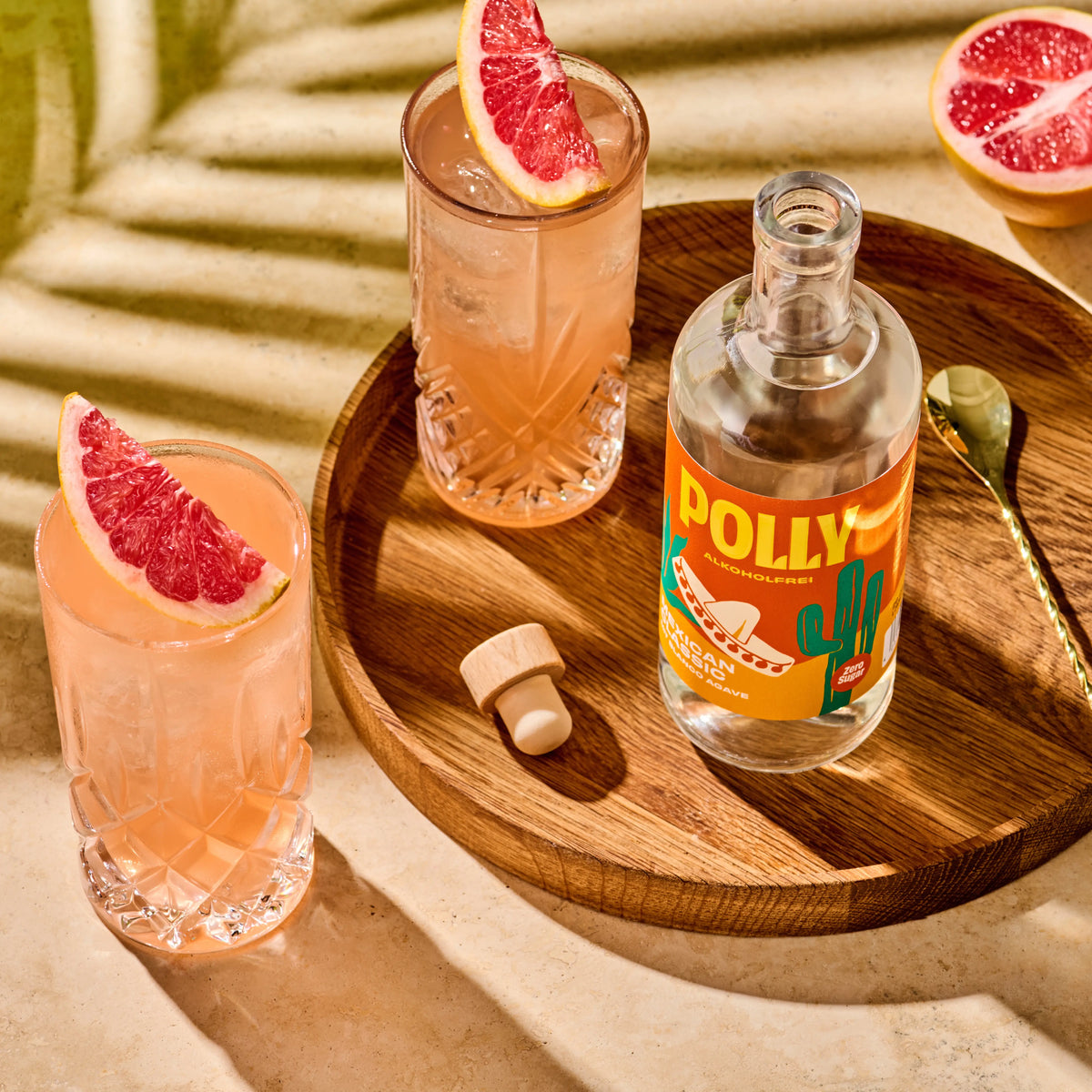 Tischszene mit zwei Gläsern mit Paloma Cocktail und einer Flasche POLLY Mexican Classic